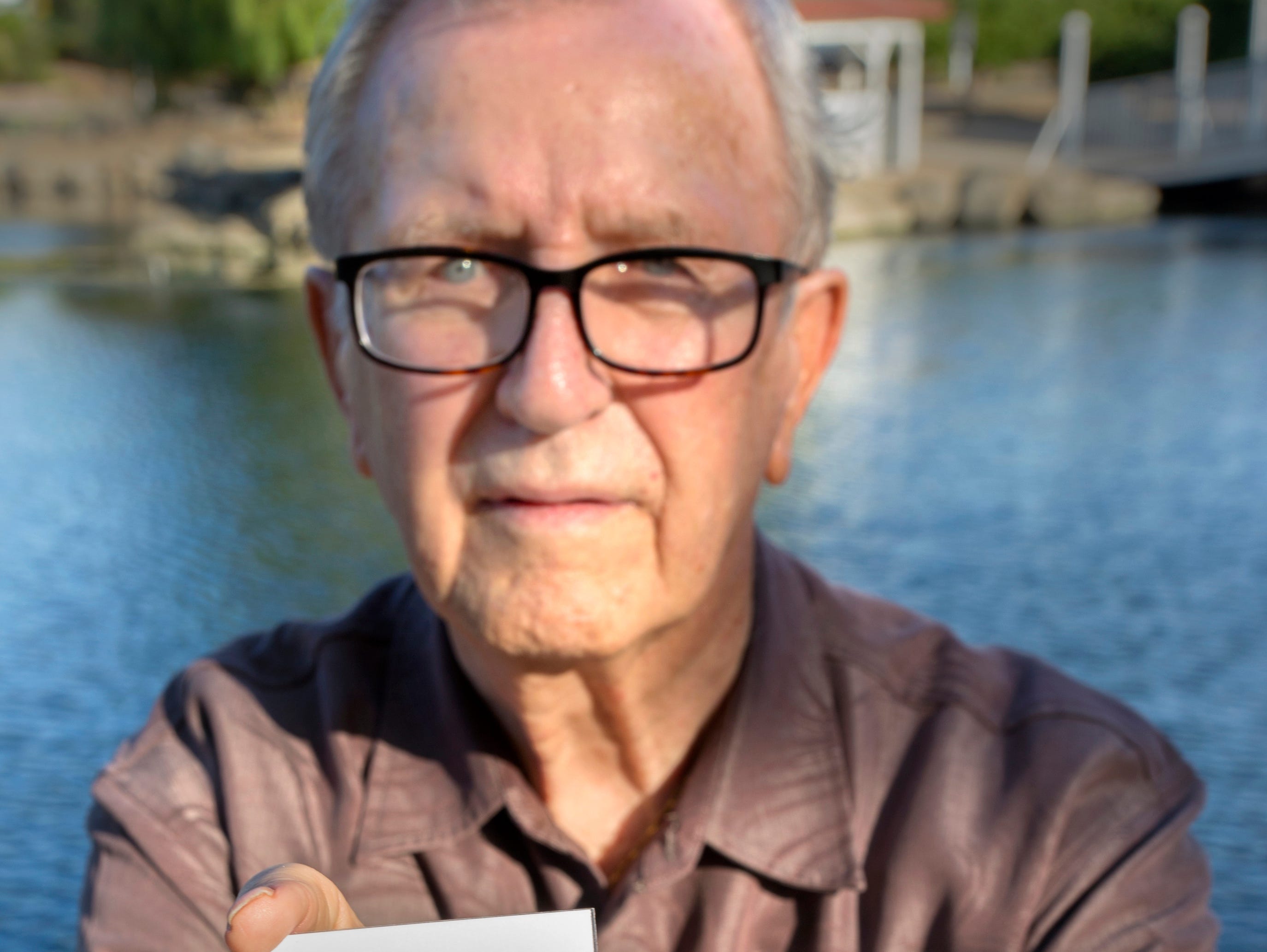 In this Friday, June 23, 2017, photo, Frank Kerrigan holds onto a a funeral card for his son Frank, near Wildomar, Calif.