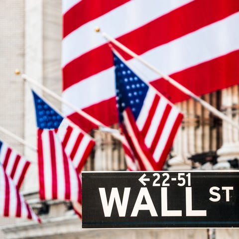 A large American flag draped over the NYSE, with t