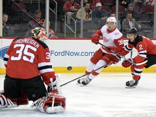 Devils defenseman John Moore (2) checks Red Wings right