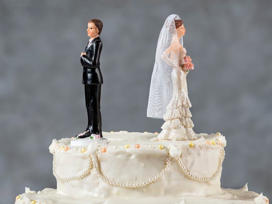 Wedding cake with bride and groom facing away from each other.