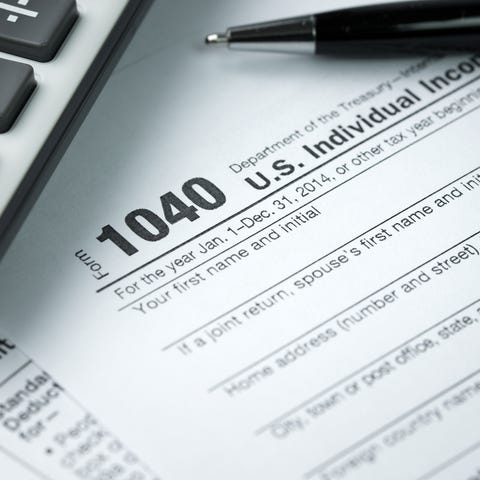 1040 tax form with calculator and pen.