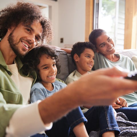 A family of four is watching TV.