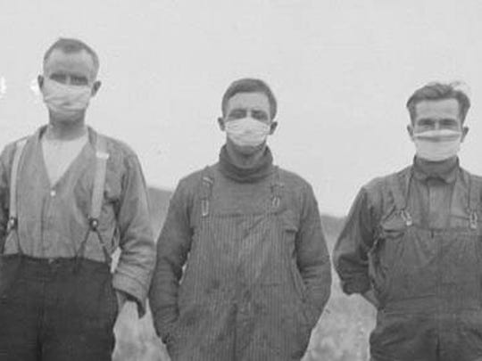 Farmers wear masks in the early 1900s to try to avoid catching the Spanish flu.