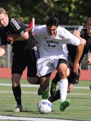 Mike Lee  and Kevin Belknap try to keep Sebastian Varela