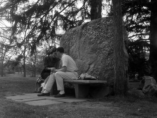 A man and woman are sitting on the bench, in front