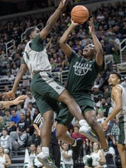 Michigan State's Cassius Winston, right, shoots as