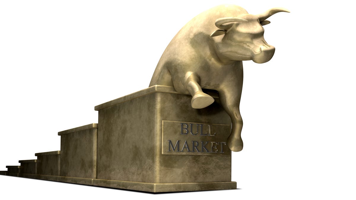 A golden bull sitting on top of a series of steps with a plaque that reads bull market on the step below the bull.