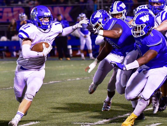 Lakeland's Sean Cullen (left) stiff-arms the Walled