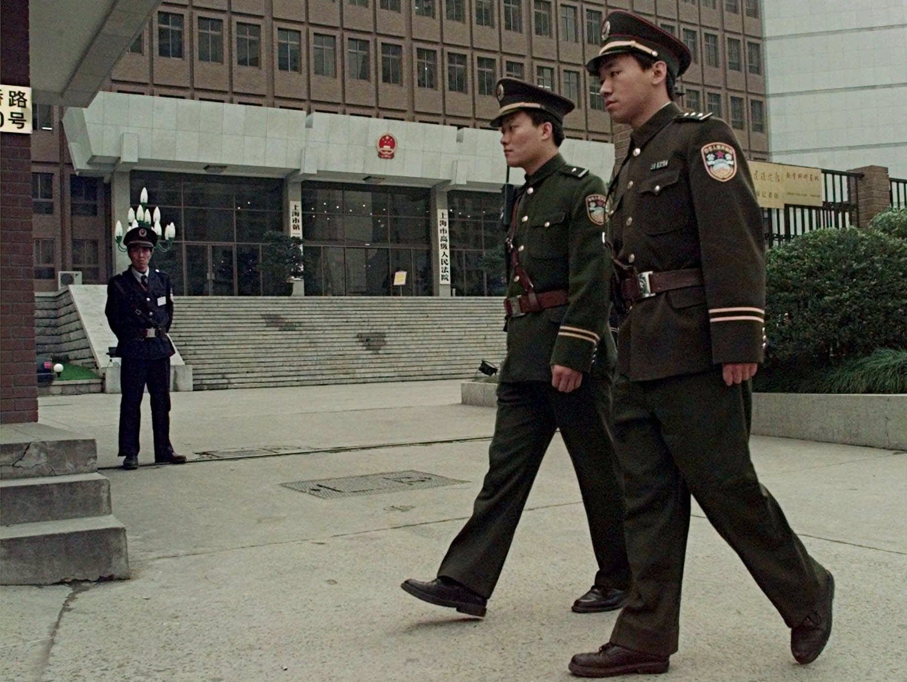 Chinese police officers patrol in front of Shanghai No.1 Intermediate People's Court Friday  Dec. 4, 1998. Lin Hai, 30, a computer entrepreneur charged with subversion for supplying Chinese e-mail address to an Internet democracy magazine is on trial