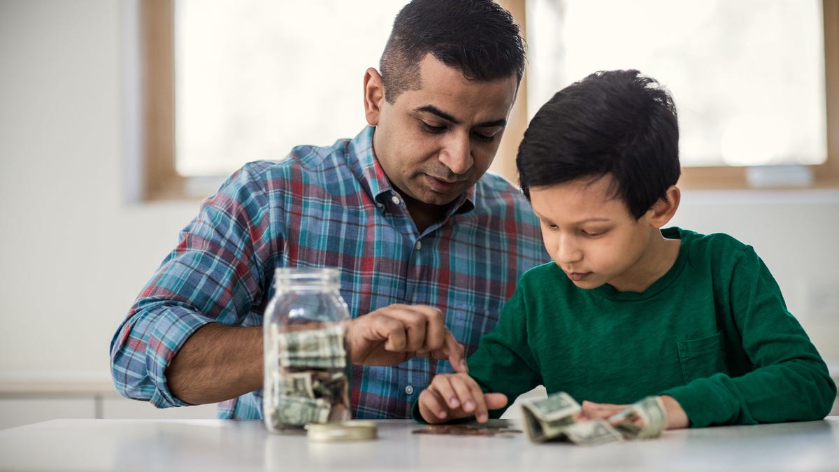 Adult and child counting money on a table.