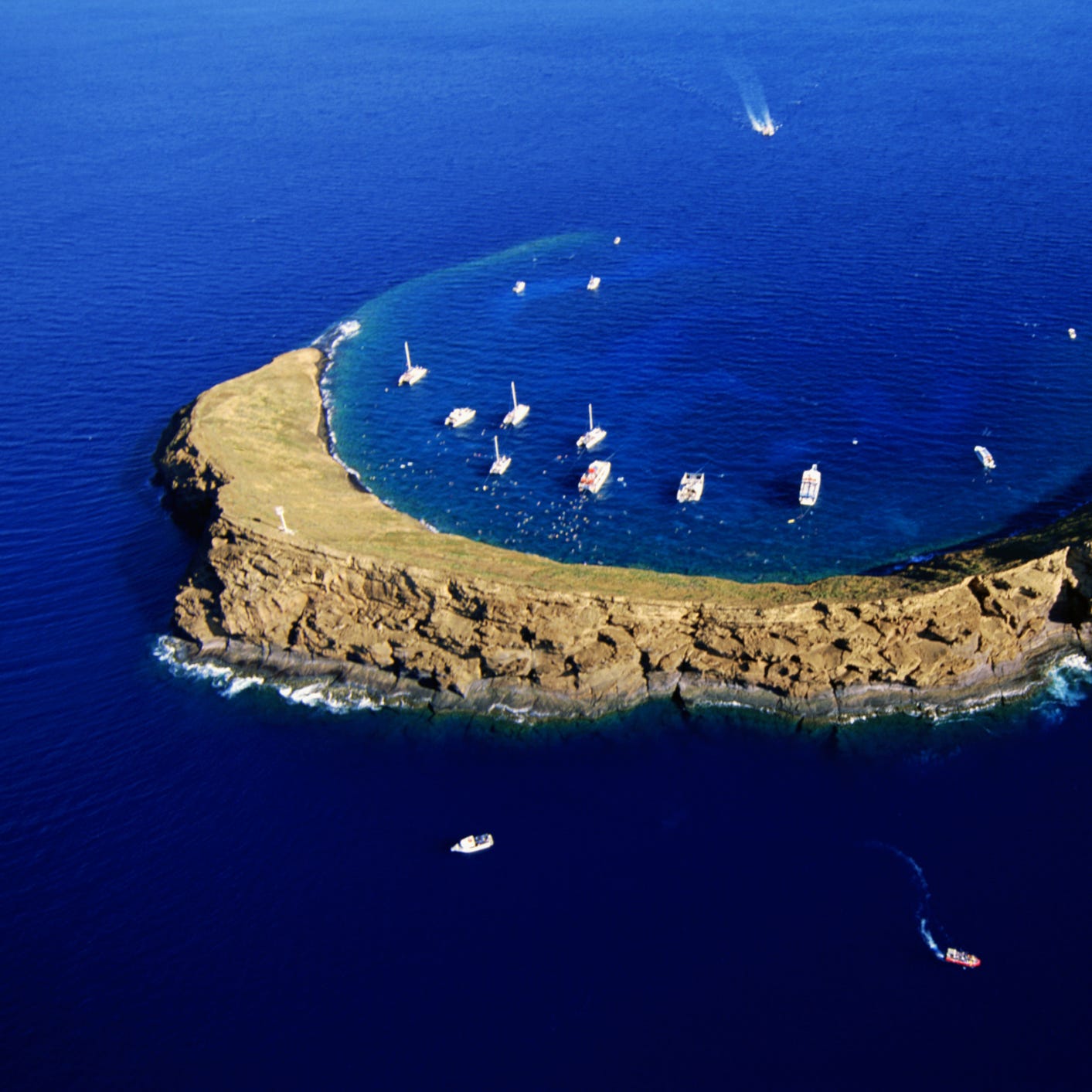 Even when it's not whale season, the waters off Hawaii's islands teem with life. Some of the state's best diving and snorkeling can be found in Molokini crater, a crescent-shaped marine sanctuary off the coast of Maui.