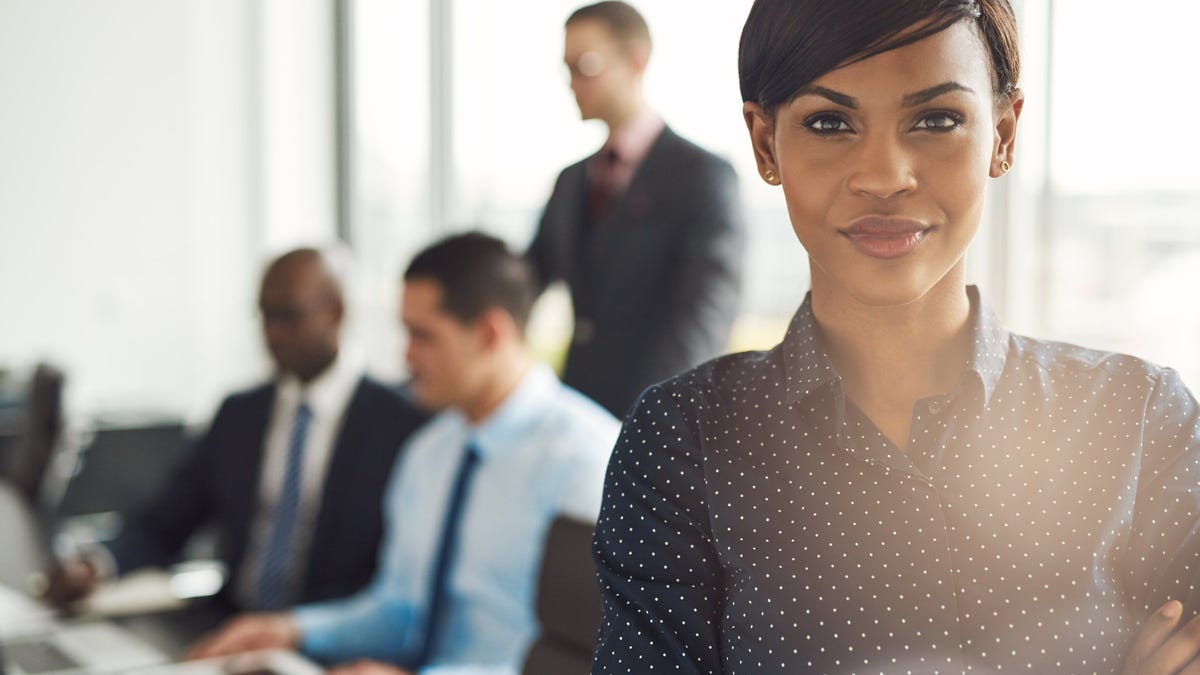 Smiling businesswoman with coworkers in background