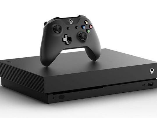 Um console de videogame Microsoft Xbox One X com um controlador acima dele.