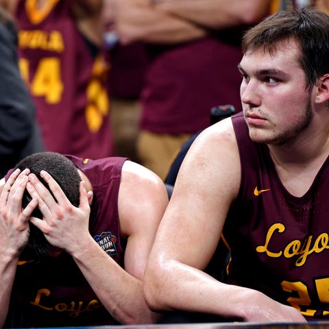 Loyola Ramblers guard Clayton Custer (13) and...