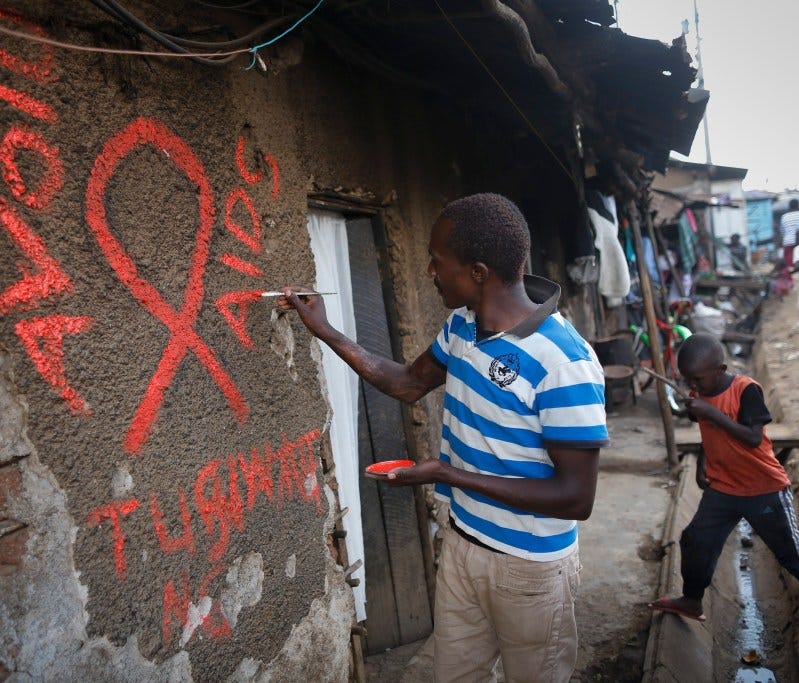 Community leader paints 'Avoid AIDS' in a Kenyan slum.