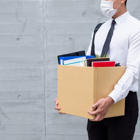 Man in shirt and tie wearing a surgical mask and h