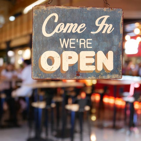 A sign on a restaurant's glass door reads Come in,