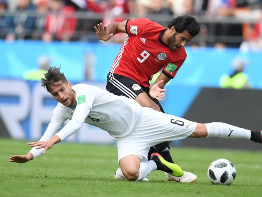 Egypt's Marwan Mohsen vies for the ball with Uruguay