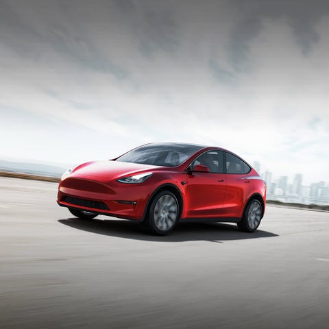 Tesla Model Y on an open lot with a cityscape behi