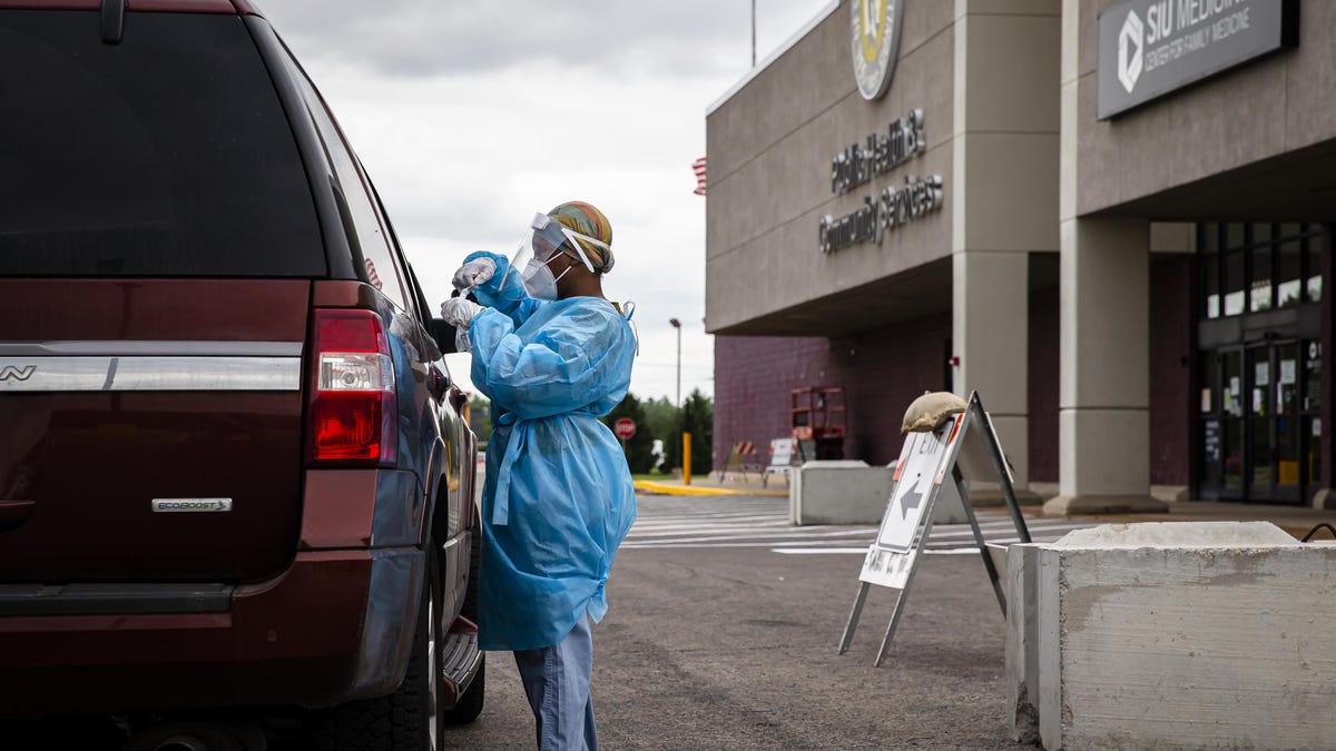 Phlebotomist Mia Jackson performs a COVID-19 test at the Illinois Dept. of Public Health's testing site at the Sangamon County Dept. of Public Health, Sunday, July 19, 2020, in Springfield, Ill. The IDPH mobile testing unit will be shutting down after Sunday and moving to the Montgomery County Public Health Dept. in Hillsboro. Local testing will still be available at the Walgreen's at 1155 N. Ninth St. for those over 18 with online registration and at Memorial Health System's ExpressCare Respiratory Clinic at 2950 S. Sixth St. with approval through TeleHealth.