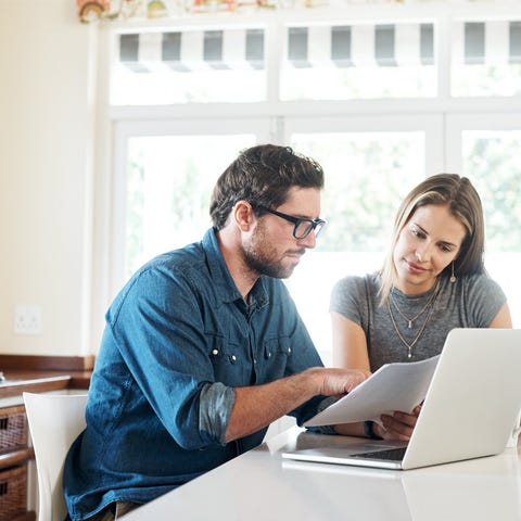 Couple discussing finances in kitchen.