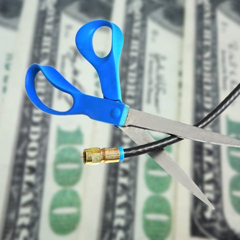 Scissors cut a cord in front of cash