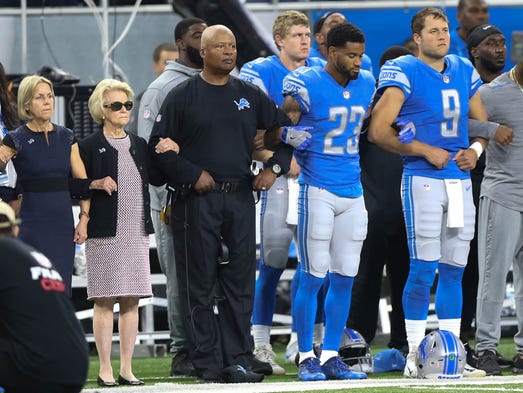 The Detroit Lions kneel and join arms in protest during