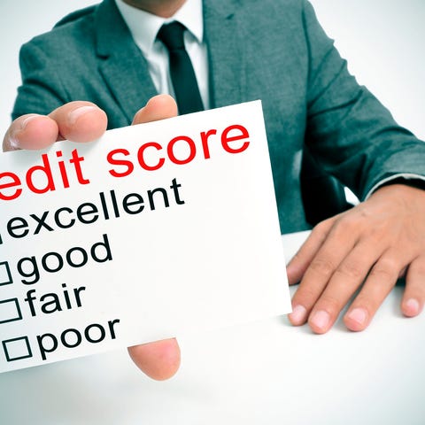 Businessman holding up credit score sign.