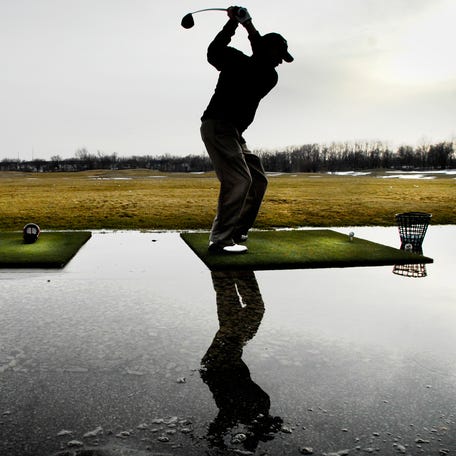Jerry Clyatt of Bartonville works on his golf swing with a bucket of balls, surrounded by a pool of melting snow at the Golf Learning Center in Peoria in 2011.