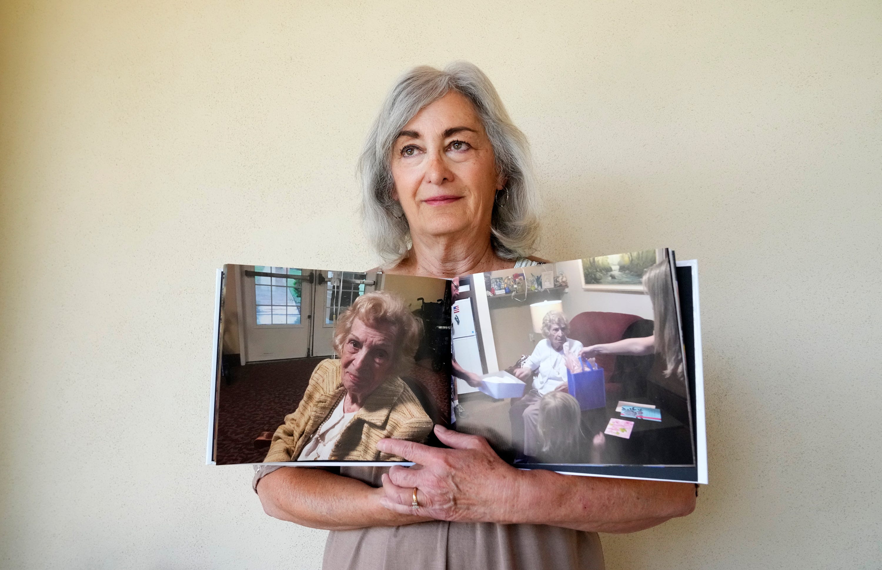 Josephine Wilson displays photographs of her mother Jennie Fischer on June 26, 2023. Fischer died after a bad fall at Brookdale North Mesa.
