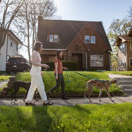 Kate Konzen and Monica Munoz walk their dogs Brandy and Petey on Monday, April 26, 2021, in their Indianapolis neighborhood. The couple hopes to buy a house soon, but strong buyer demand and a limited inventory of available homes is continuing toÂ drive up prices.