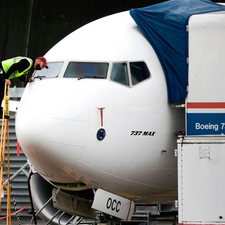 A worker inspects a Boeing 737 MAX airliner at Renton Airport adjacent to the Boeing Renton Factory in Renton, Washington on November 10, 2020. U.S. regulators on November 18, 2020 cleared the Boeing 737 MAX to take to the skies again, ending its 20-month grounding after two fatal crashes.