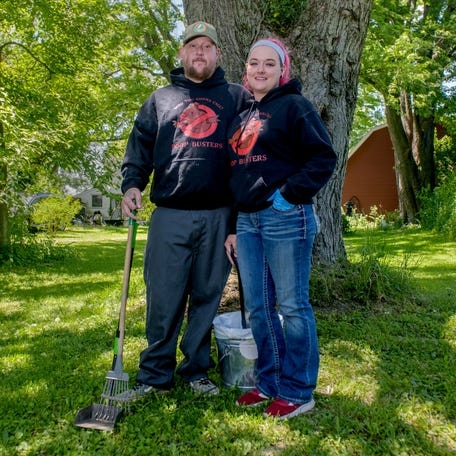 Dog owners Christopher Dykes, left, and Allie Howarter of Washington have turned the unpleasant task of pet-waste removal into a lucrative business. The couple started Poop Busters in January and have seen their clientele grow dramatically.