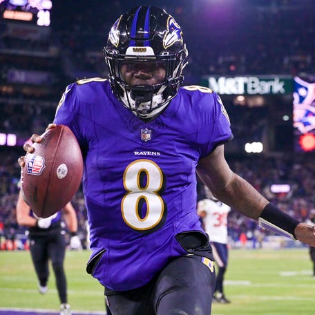 Baltimore Ravens quarterback Lamar Jackson (8) reacts after running past for Houston Texans defensive tackle Sheldon Rankins (98) for a touchdown during the fourth quarter in an AFC divisional-round game at M&T Bank Stadium.