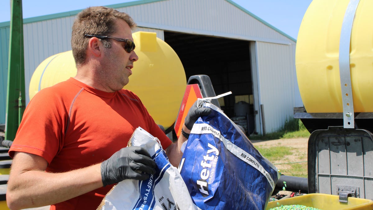 Jason Haglund, who is trained as an addiction treatment counselor and is a mental health advocate, loads corn seeds into a planter on his family's farm near Boone, Iowa, on May 17, 2024. His family has farmed in the area for about 140 years, and he represents the fifth generation doing the work.