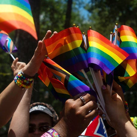 Guests receive Pride flags at an after party following a Pride parade at Bonnaroo in Manchester, Tenn., Saturday, June 15, 2024.