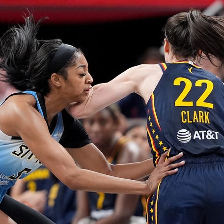 Angel Reese hand-checks Caitlin Clark during Sunday's game between the Chicago Sky and Indiana Fever in Indianapolis.