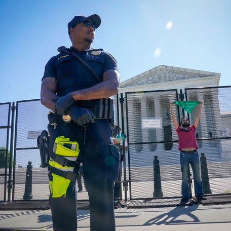 Jun 6, 2022; Washington, DC, USA; A pro-abortion rights protester chains himself to the security fence in front of the United States Supreme Court on Monday, June 6, 2022. Mandatory Credit: Jack Gruber-USA TODAY