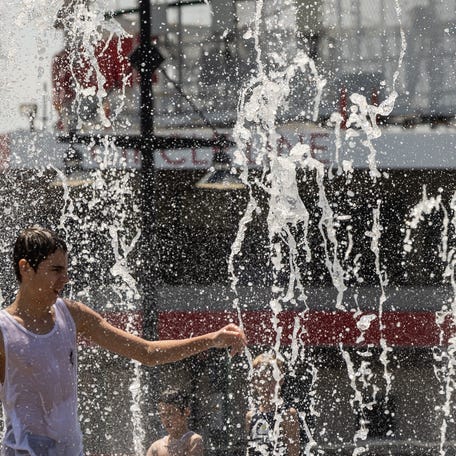 A person cools off in a water fountain near the Hudson River during a heatwave on June 20, 2024 in New York City. Deadly heat that has blanketed the US, Mexico and Central America recently was made 35 times more likely due to global warming, World Weather Attribution (WWA) climate scientists said on June 20. (Photo by Yuki IWAMURA / AFP) (Photo by YUKI IWAMURA/AFP via Getty Images)