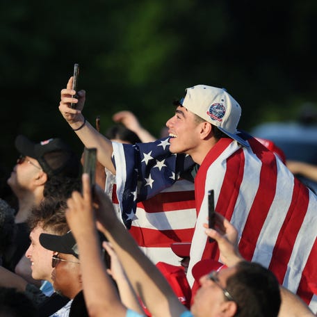 A young man draped in the U.S. flag attends a campaign rally attended by former U.S. President Donald Trump at Crotona Park in Bronx, New York on May 23, 2024.