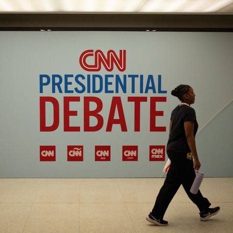 A woman walks past a sign in the press room at the McCamish Pavilion on the Georgia Institute of Technology campus ahead of the first 2024 presidential debate in Atlanta, Georgia on June 27, 2024.