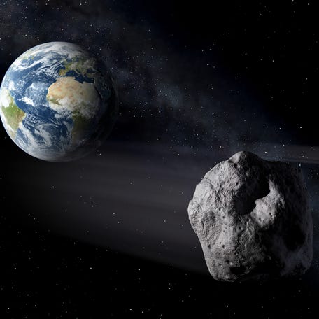 Conceptual artist's rendering of two asteroids passing Earth.