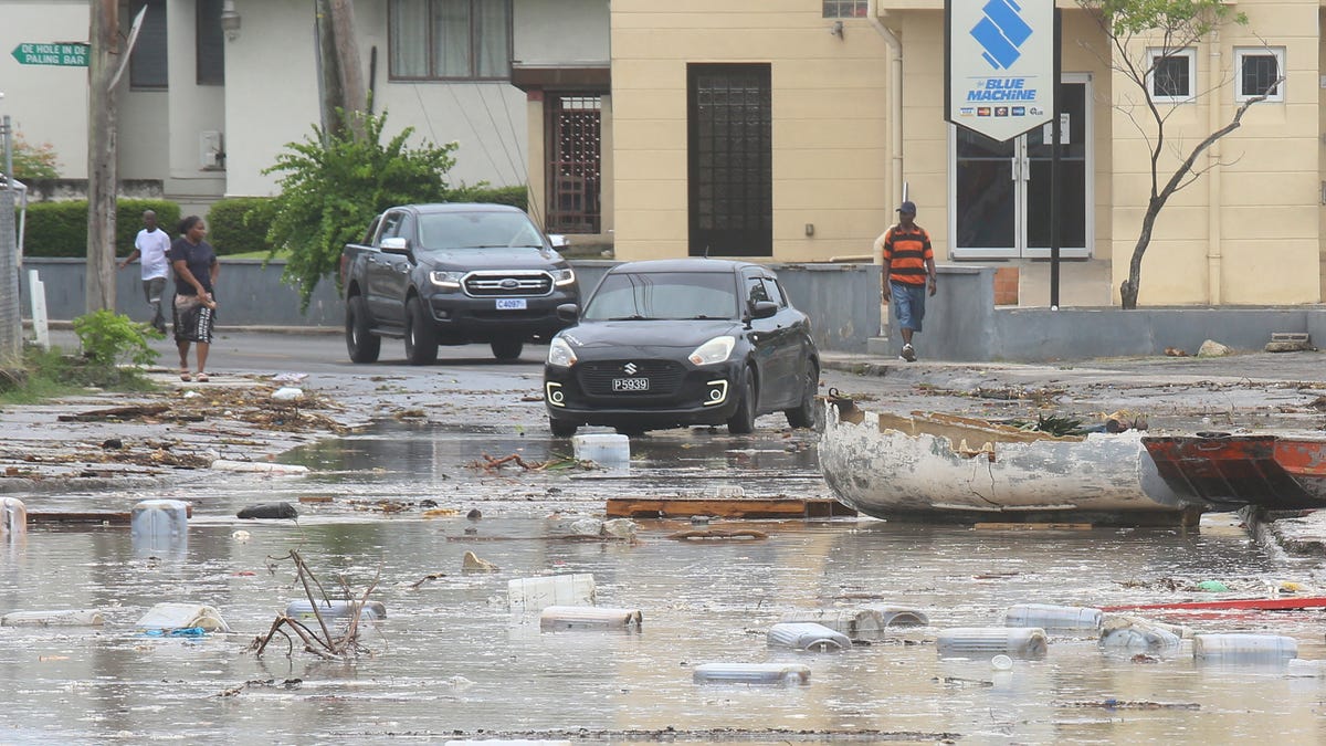 Cars enter a debris-filled street in the Hastings neighborhood after Hurricane Beryl passed in Bridgetown, Barbados July 1, 2024.
