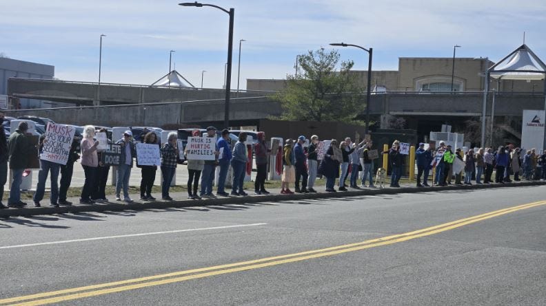 Protesters gather at Tesla charging stations at Auburn Mall