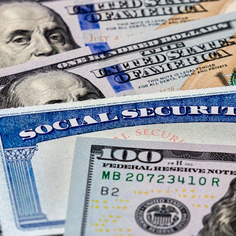 Social Security card in a stack of money.