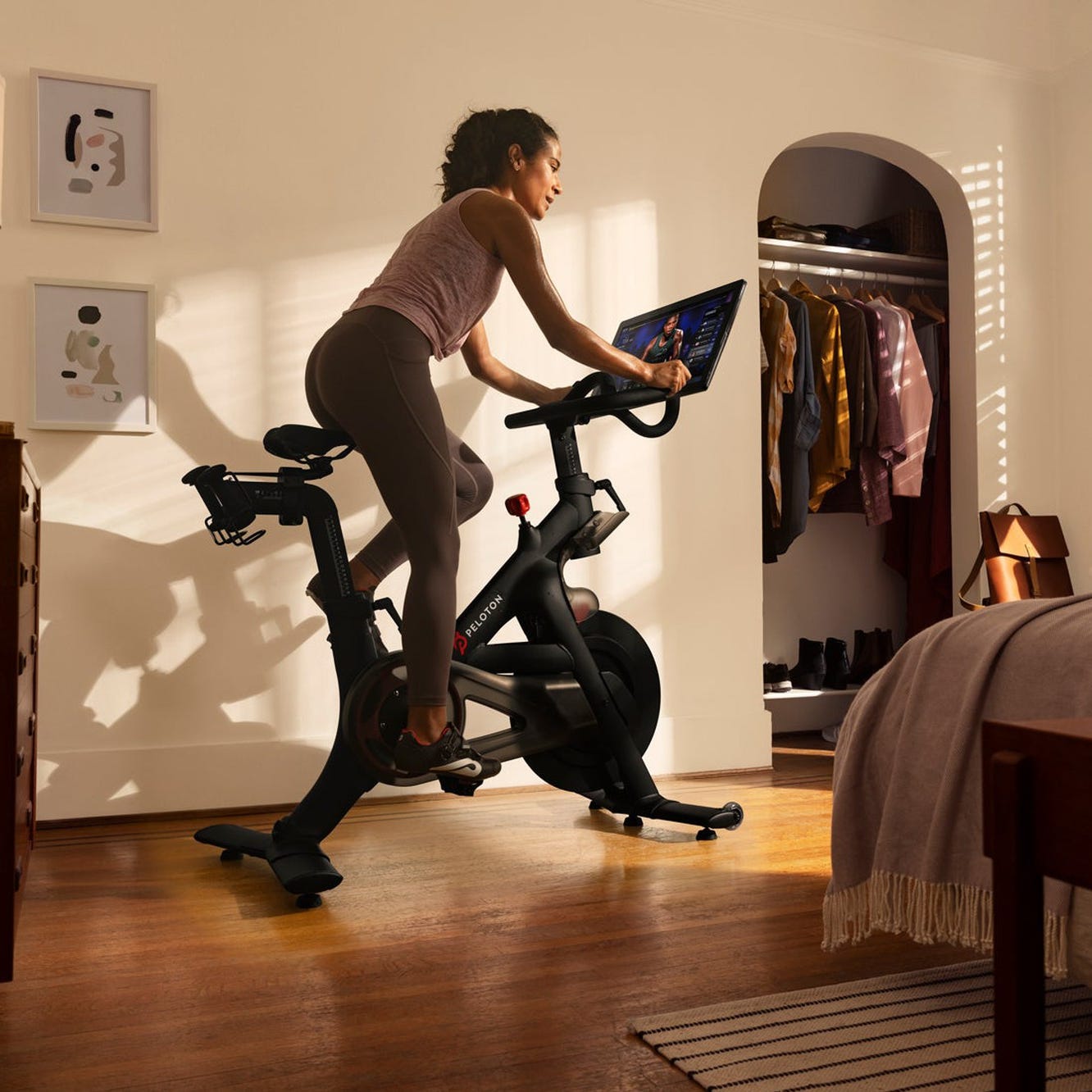 A person using their Peloton exercise bike in their bedroom.