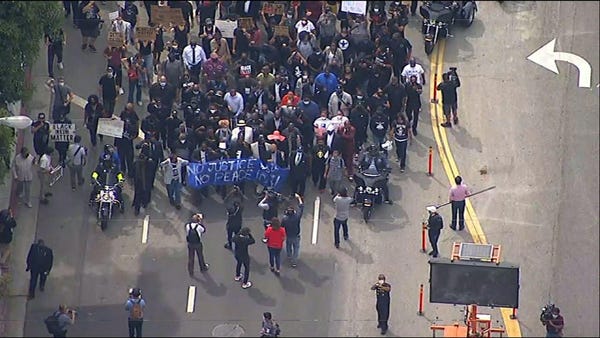 Protesters sit down on downtown Los Angeles street