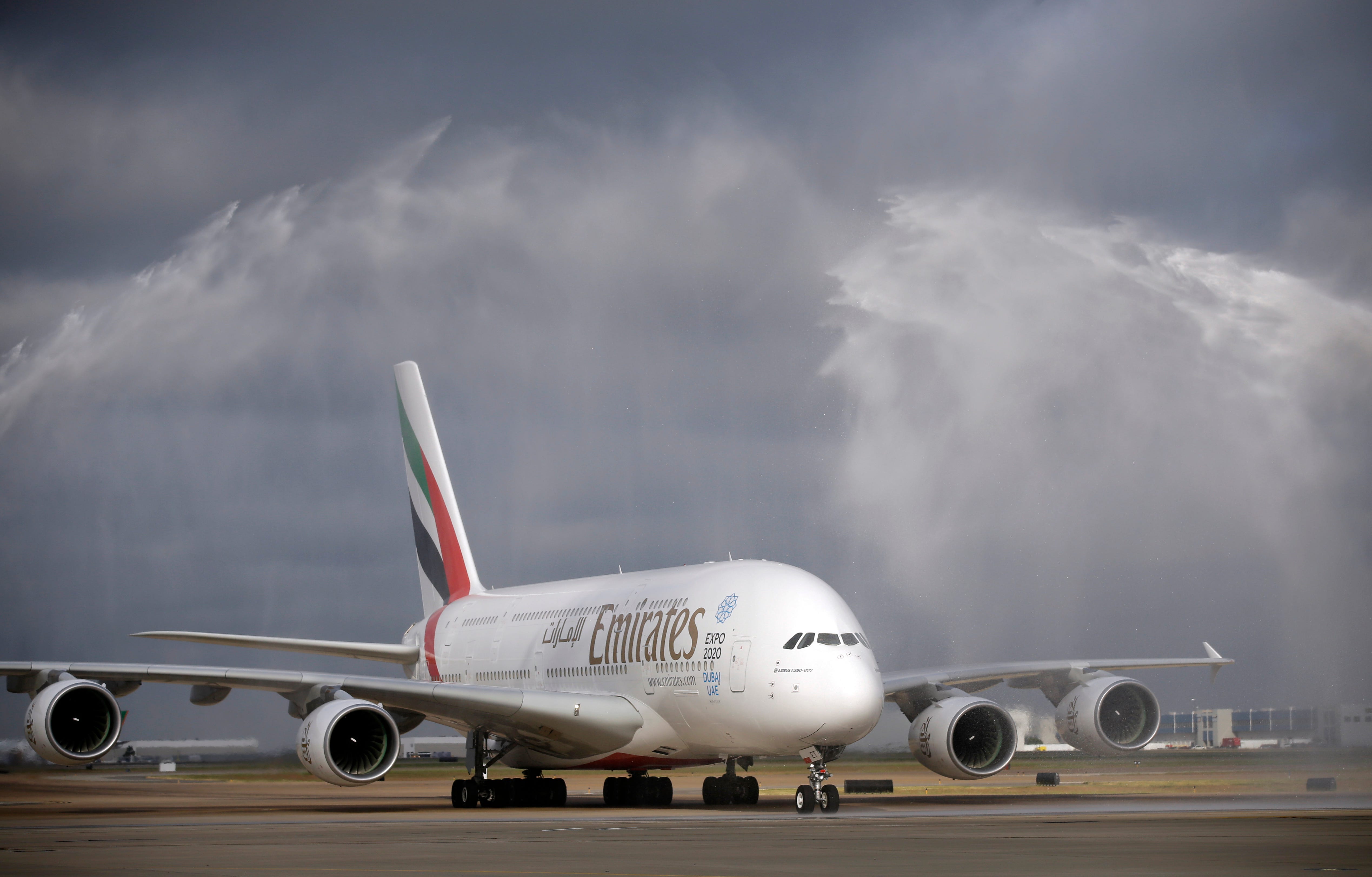 an emirates airbus a380 is showered by water canons