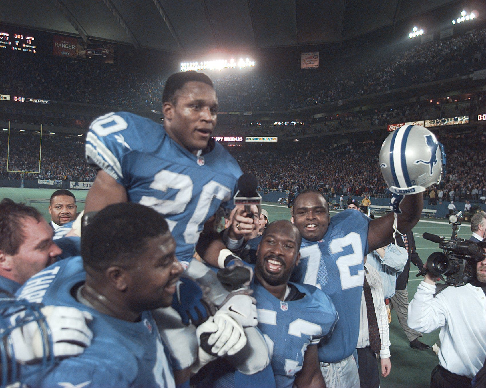 Detroit Lions running back Barry Sanders is carried on the shoulders of teammates after reaching the 2,000-yard milestone in 1997.