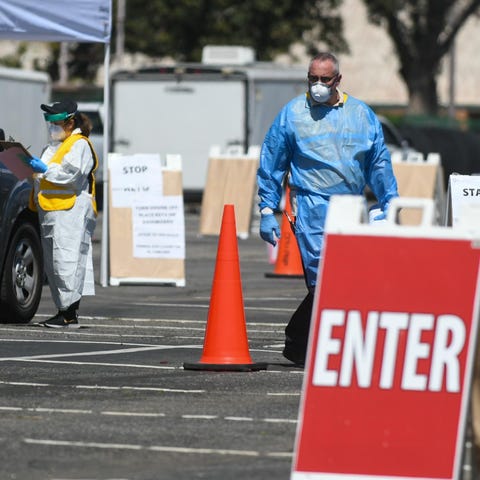 Health officials at a COVID-19 testing site in San